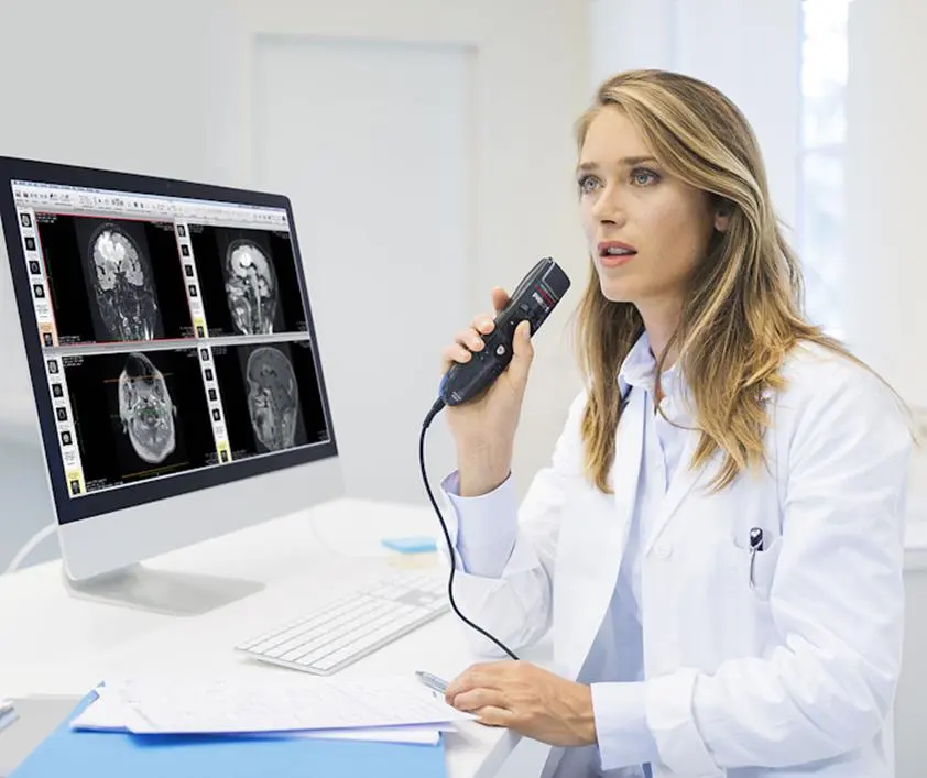 Médica radiologista ditando achados com microfone de ditado diante de imagens de ressonância